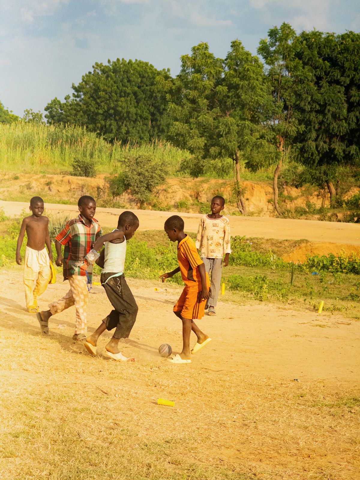 Kids playing football together on a sunny field